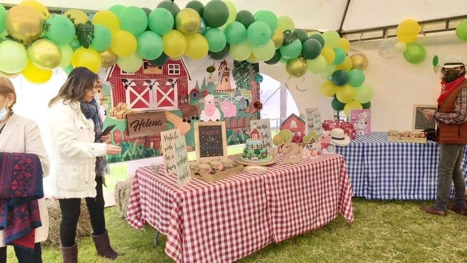 Decoración temática de fiesta infantil en El Nodo Glamping con globos, mesas campestres y ambiente natural